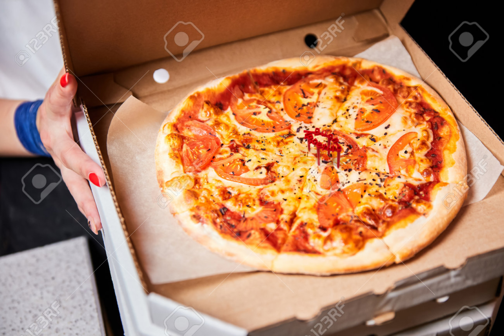 192218123-ragazza-che-tiene-una-pizza-in-una-scatola-aperta-preparandola-per-la-consegna