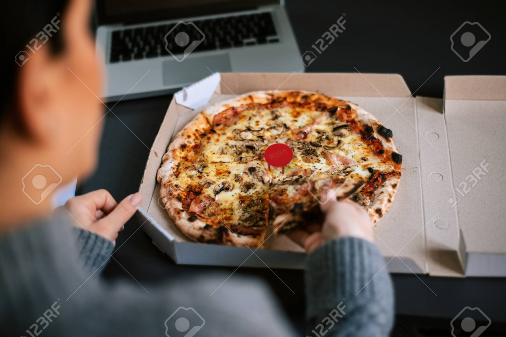 96124059-donna-che-mangia-pizza-mentre-lavora-al-computer-portatile